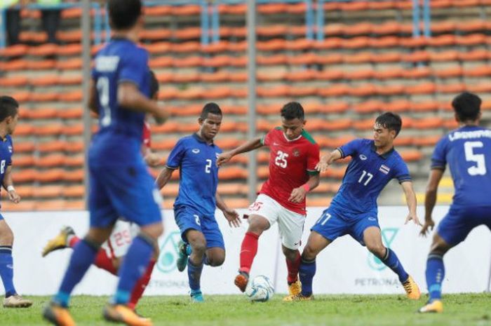 Winger timnas U-22 Indonesia, Osvaldo Haay (tengah) dikawal tiga pemain timnas U-22 Thailand pada laga perdana Grup B SEA Games 2017 di Stadion Shah Alam, Selangor, Malaysia, 15 Agustus 2017. 