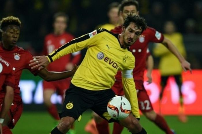 Aksi bek Borussia Dortmund, Mats Hummels (kuning), di antara kepungan pemain Bayern Muenchen dalam duel Bundesliga di Signal Iduna Park, 5 Maret 2016.