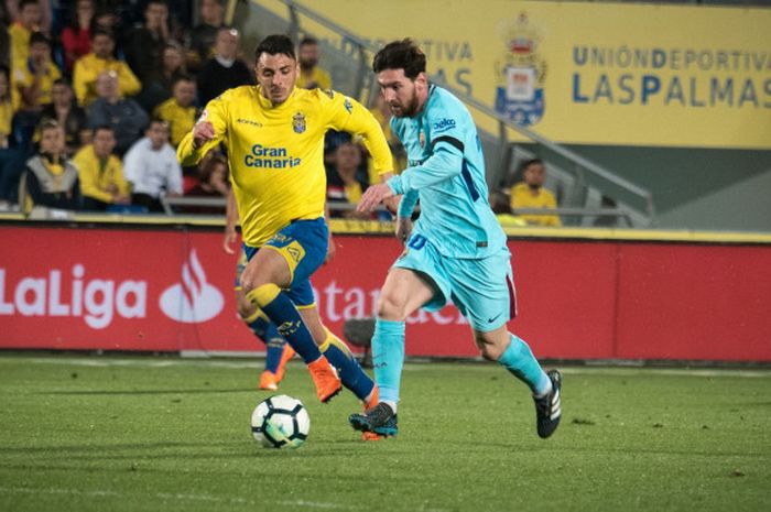 Striker utama Barcelona, Lionel Messi, mendapat pengawalan ketat dari pemain tuan rumah Las Palmas, Ximo Navarro Jimenez, dalam laga lanjutan Liga Spanyol di Stadion Gran Canaria, Jumat (2/3/2018).