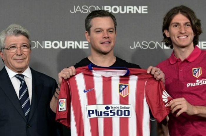 Aktor peran Hollywood, Matt Damon (tengah), berpose bersama pemain Atletico Madrid, Filipe Luis (kanan) dan presiden Atletico, Enrique Cerezo, sambil memamerkan seragam Atletico dalam acara promo film 'Jason Bourne' di Madrid, Spanyol. 