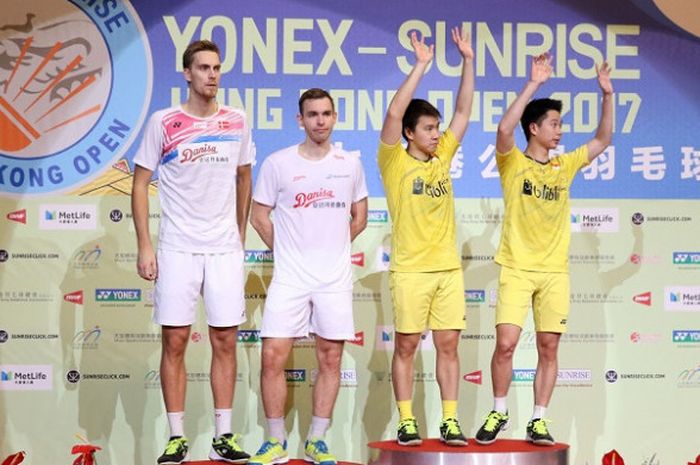 Pasangan ganda putra Indonesia, Marcus Fernaldi Gideon/Kevin Sanjaya Sukamuljo (kanan),memberikan salam di atas podium setelah mengalahkan Mads Conrad-Petersen/Mads Pieler Kolding (Denmark), dengan skor 21-12, 21-18 pada laga final yang berlangsung di Hong Kong Coliseum, Minggu (26/11/2017).