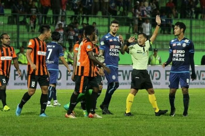 Wasit Annas Apriliandi (dua dari kanan) dengan tangan ke atas membulatkan keputusannya dari protes pemain saat Arema FC menjamu Perseru Serui pada pekan ke-10 Liga 1 musim 2017 di Stadion Gajayana, Kota Malang, Sabtu (10/6/2017) malam. 