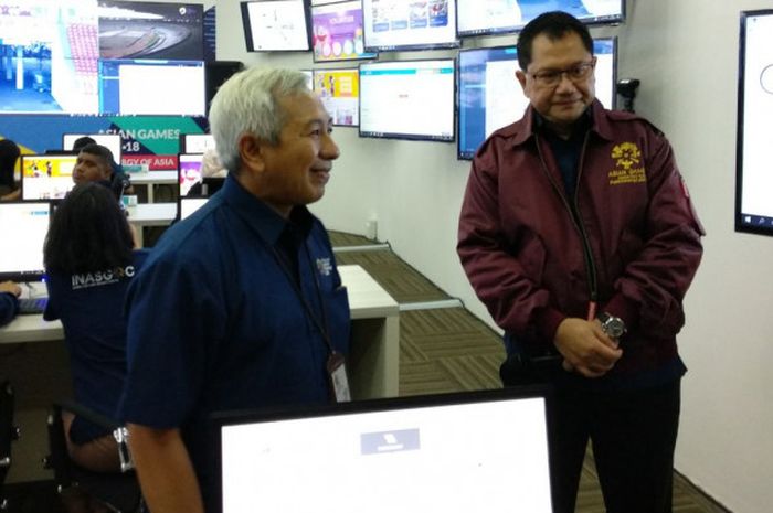 Direktur IT dan Telekomunikasi Inasgoc, Edy Prabowo (kanan), sedang menjelaskan fungsi monitor yang ada di Main Operation Center di Kantor Inasgoc, Jakarta, Rabu (31/1/2018).