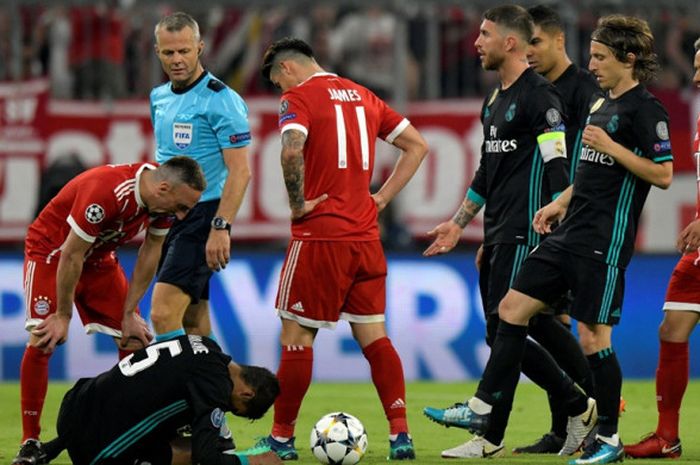    Pemain Bayern Muenchen, James Rodriguez (ketiga dari kiri), melihat kondisi bek Real Madrid, Raphael Varane, dalam laga leg pertama semifinal Liga Champions di Stadion Allianz Arena, Muenchen, Jerman pada 25 April 2018.    