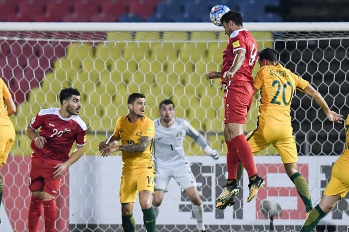 Penyerang Suriah, Omar Al Somah, memenangi perebutan bola udara di depan gawang Australia dalam laga play-off Piala Dunia 2018 di Stadion Hang Jebat, Malaysia, Kamis (5/10/2017) malam WIB.
