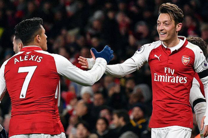 Gelandang Arsenal, Mesut Oezil (kanan), melakukan selebrasi bersama rekan setimnnya Alexis Sanchez, seusai mencetak gol ke gawang Huddersfield Town dalam laga lanjutan Inggris 2017-2018 di Stadion Emirates, London, pada 29 November 2017.
