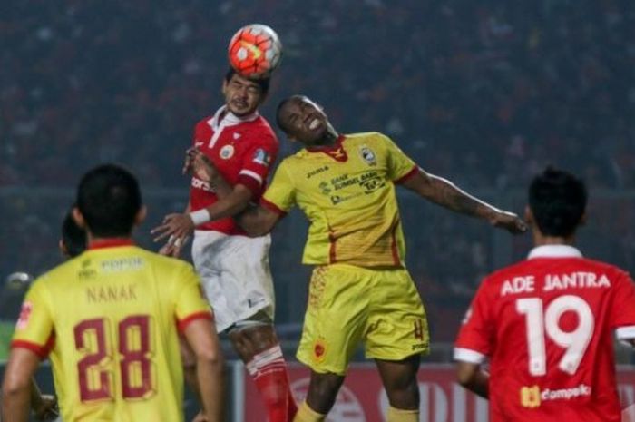  Duel di udara striker Persija, Bambang Pamungkas dan bek Sriwijaya FC, Mauricio Leal di SUGBK, Jakarta pada Jumat (24/6/2016) malam.  