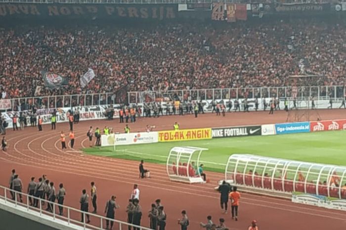 Aparat keamanan berjaga di area pembatas tribune penonton dan area permainan untuk mencegah penonton masuk ke lapangan pada akhir laga Persija Jakarta kontra Mitra Kukar di SUGBK, Minggu (9/12/2018).