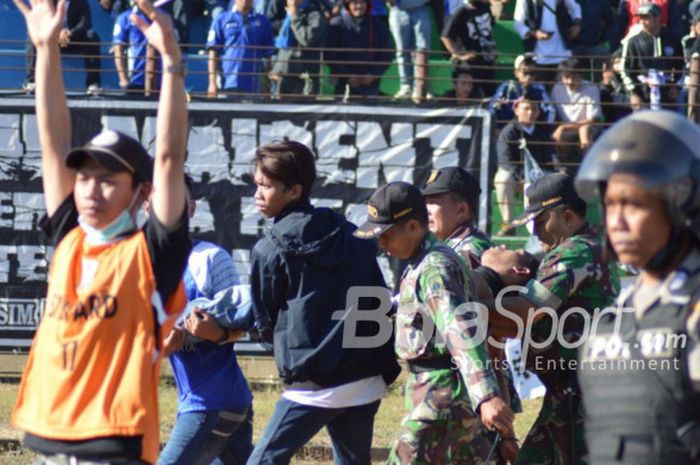 Salah satu suporter mendapatkan bantuan dari steward dan petugas pengamanan pada awal pertandingan PSIM Yogyakarta kontra PSS Sleman di Stadion Sultan Agung (SSA), Bantul, Kamis (26/7/2018) sore WIB.