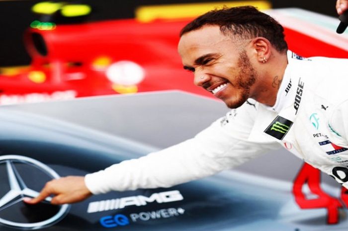 Lewis Hamilton saat berpose dengan mobil Mercedes yang ditungganginya pada F1 2018.
