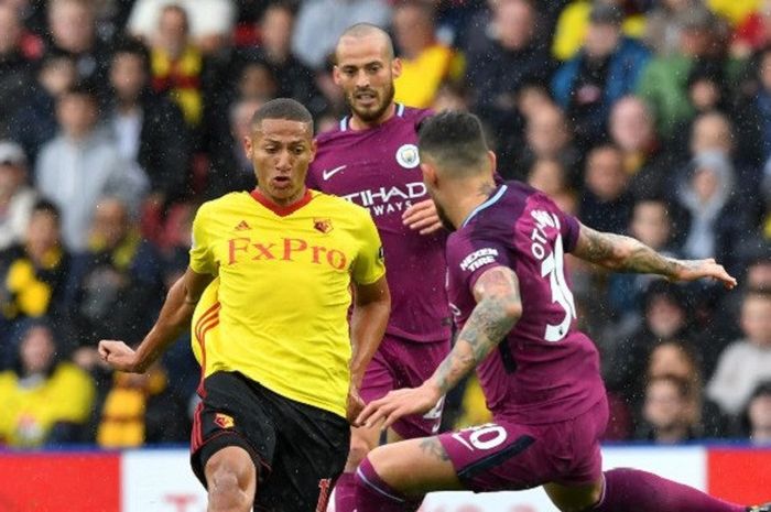 Striker baru Watford asal Brasil, Richarlison de Andrade mendapat hadangan dari bek Manchester City Nicolas Otamendi di laga Liga Inggris pada 16 September 2017.