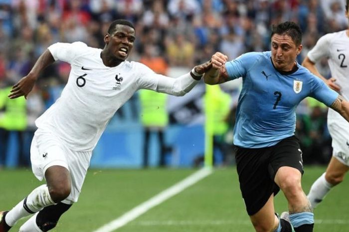 Paul Pogba (kiri) berebut bola dengan Cristian Rodriguez dalam partai babak 8 besar Piala Dunia 2018 Uruguay vs Prancis di Nizhny Novgorod, 6 Juli 2018.