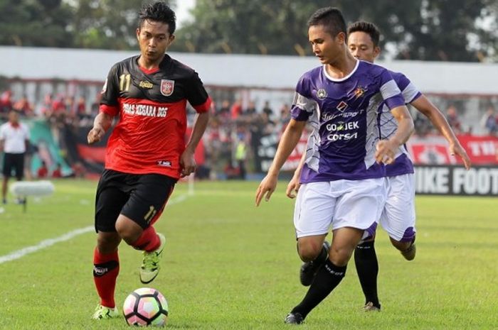 Pemain Mojokerto Putra, Rezzy Syarifianto (kiri) berduel dengan pemain Persik Kediri, Febly Gushendra.