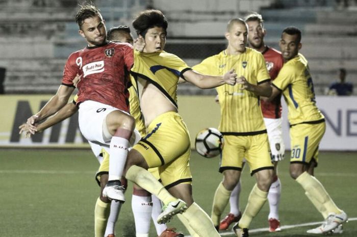 Penyerang Bali United, Ilija Spasojevic berjibaku dengan pemain Global Cebu pada pertandingan kedua fase Grup G Piala AFC 2018, di Stadion Rizal Memorial, Selasa (27/2/2018).