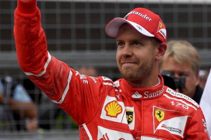Pebalap Ferrari asal Jerman, Sebastian Vettel, melambaikan tangan ke suporter setelah menyelesaikan sesi kualifikasi GP Jepang di Sirkuit Suzuka, Minggu (7/10/2017).