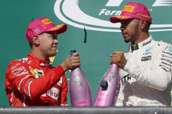    Pebalap Ferrari, Sebastian Vettel (kiri), berbincang-bincang dengan pebalap Mercedes, Lewis Hamilton (kanan), di atas podium seusai balapan GP Amerika di Circuit of the Americas, 22 Oktober 2017.   