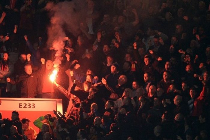 Suporter Liverpool menyalakan flare pada laga kontra Manchester United di Stadion Old Trafford, Kamis (17/3/2016). 