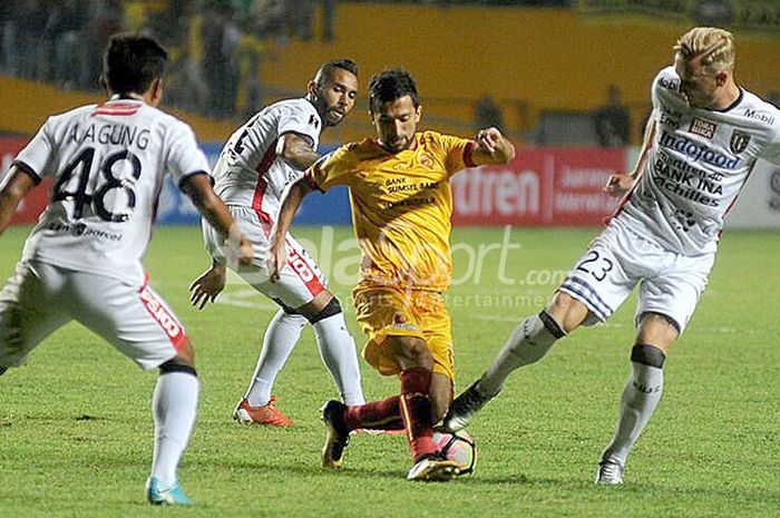 Pemain Sriwijaya FC,  Manuchekhr Dzhalilov (tengah), berusaha melewati hadangan pemain Bali United pada laga leg pertama semifinal piala Presiden di Stadion Gelora Sriwijaya Jakabaring Palembang, Minggu (11/2/2018).