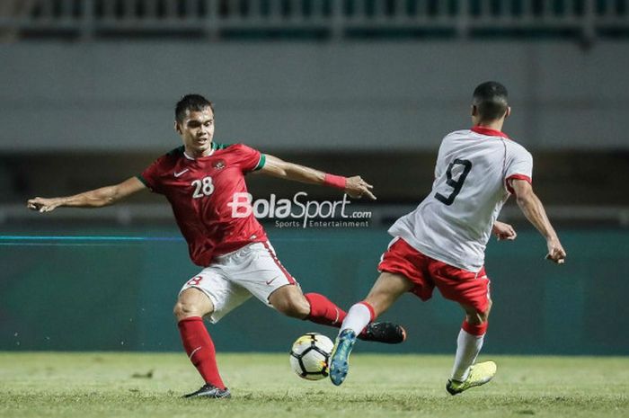 Bek Timnas U-23 Indonesia, Rezaldi Hehanussa, berduel memperebutkan bola pada laga PSSI Anniversary Cup 2018 kontra Bahrain di Stadion Pakansari, Bogor, Jumat (27/4/2018)
