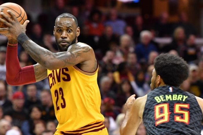 Pemain bintang Cleveland Cavaliers, LeBron James (jersey kuning, #23), berupaya melewati penjagaan pemain Atlanta Hawks, DeAndre' Bembry (#95), saat bertanding di Quicken Loans Arena, Cleveland, Ohio, Jumat (7/4/2017).