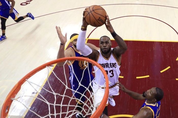 Bintang Cleveland Cavaliers, LeBron James (jersey putih, #23), melakukan slam dunk seraya dijaga pemain Golden State Warriors, JaVale McGee (jersey biru, #1), pada gim ketiga final NBA di Quicken Loans Arena, Cleveland, Ohio, Rabu (7/6/2017) malam waktu setempat atau Kamis pagi WIB.