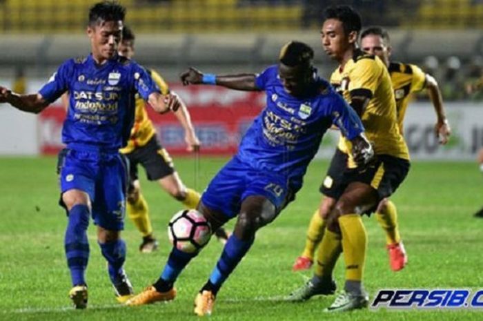 Striker Persib Bandung, Ezechiel N Douassel, saat dihadang pemain Barito Putera di Stadion Si Jalak Harupat, Bandung.