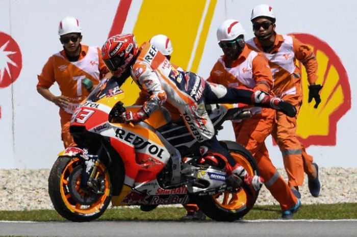 Pebalap Repsol Honda Team, Marc Marquez, sedang mendorong motornya setelah terjatuh pada sesi kualifikasi GP Malaysia di Sirkuit Sepang, Sabtu (28/10/2017).