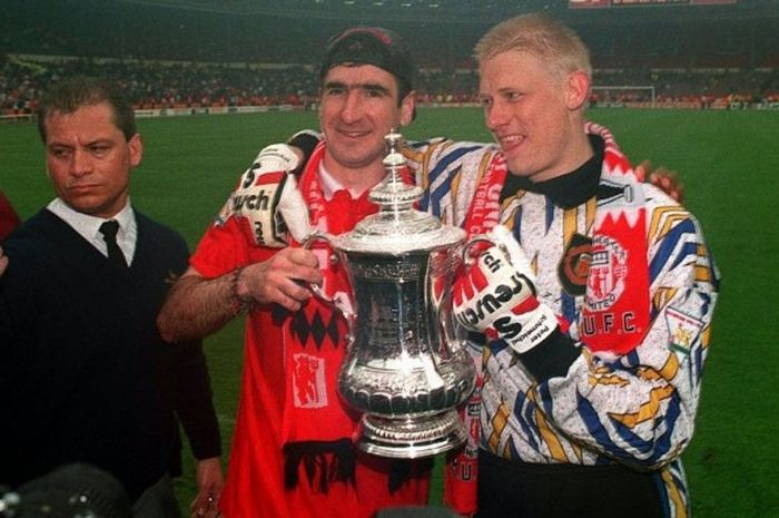  Peter Schmeichel (kanan) berpose bersama Eric Cantona dengan memegang trofi Piala FA yang dimenangi