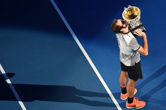 Petenis Swiss, Roger Federer, mencium trofi Australia Terbuka 2017 yang diraih setelah memenangi pertandingan final atas Rafael Nadal (Spanyol) di Rod Laver Arena, Melbourne Park, Melbourne, 29 Januari lalu.
