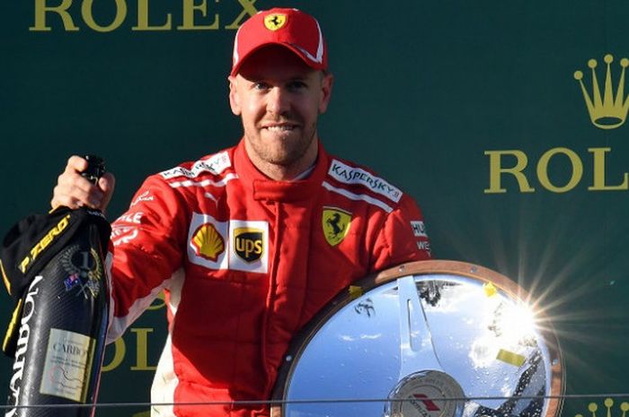 Pebalap Ferrari, Sebsatian Vettel, berpose dengan trofi yang didapat sebagai juara balapan GP Australia yang berlangsung di Sirkuit Melbourne Grand Prix, Minggu (25/3/2018).