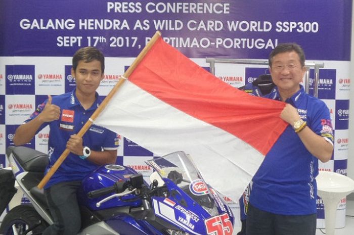 Pebalap Yamaha Indonesia, Galang Hendra Pratama, berpose dengan membentang bendera Indonesia bersama Presiden Direktur PT Yamaha Indonesia Motor Manufacturing, Minoru Morimoto, di Jakarta, Kamis (31/8/2017).
