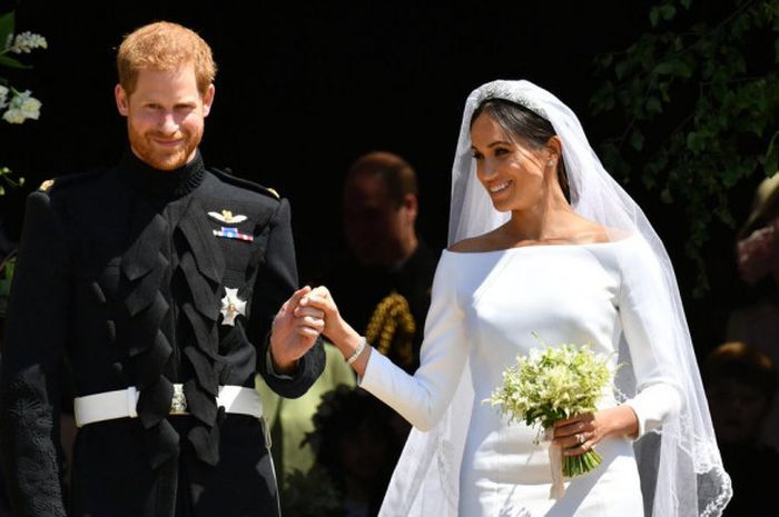 Pangeran Harry (kiri) dan Meghan Markle (kanan) pada momen Royal Wedding yang terjadi pada Sabtu (19/5/2018).