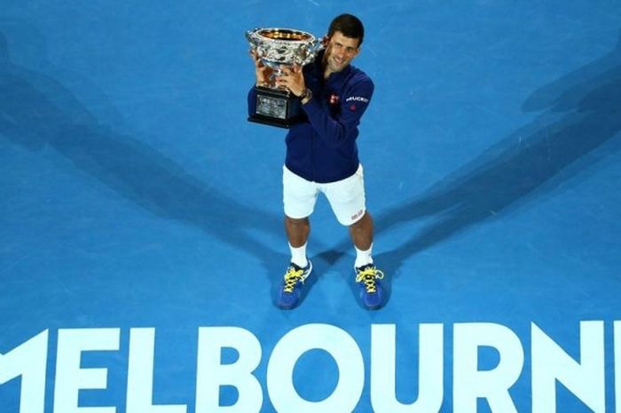 Petenis Serbia, Novak Djokovic, berpose dengan trofi juara Australia Terbuka yang didapat setelah mengalahkan Andy Murray (Inggris Raya) pada laga final di Rod Laver Arena, Melbourne Park, Minggu (31/1/2016).