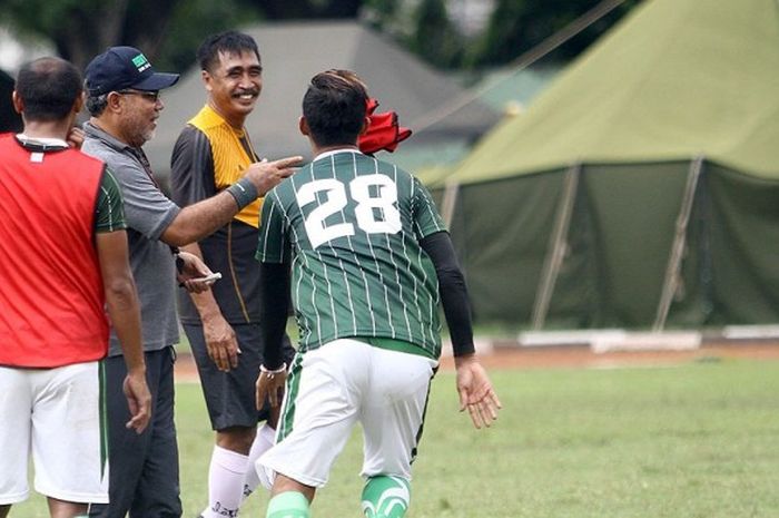 Pelatih Persebaya, Iwan Setiawan memegang rompi untuk di lempar sebelum sesi latihan game dimulai.