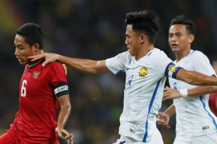 Kapten sekaligus gelandang timnas U-22 Indonesia, Evan Dimas coba dihentikan bek tengah yang juga kapten timnas U-22 Malaysia, Adib Zainuddin pada semifinal SEA Games 2017 di Stadion Shah Alam, Selangor, Sabtu (26/8/2017) malam. 