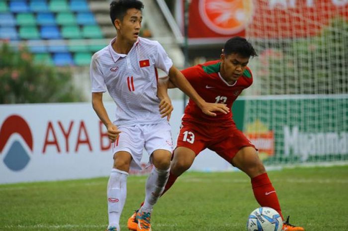 Bek timnas U-19 Indonesia, Rachmat Irianto (kanan) berduel dengan penyerang timnas U-19 Vietnam, Le Xuan Tu pada laga ketiga Grup B Piala AFF U-18 2017 di Stadion Thuwunna, Yangon, Senin (11/9/2017).