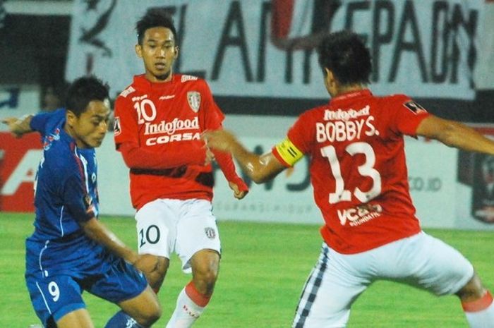 Dua pemain Bali United, Bobby Satria dan Loudry Setiawan (kaos tim merah-putih) berupaya mengawal pergerakan striker Arema Cronus, Syamsul Arif, pada babak penyisihan grup B turnamen Piala Jenderal Sudirman di Stadion Kapten Dipta, Gianyar.