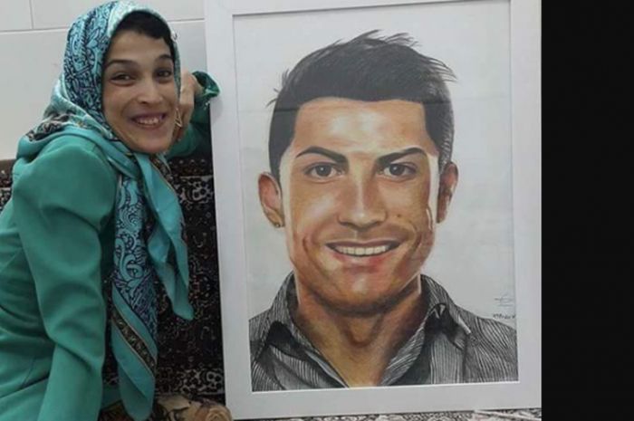Seniman asal Iran, Fatemeh Hamami berpose bersama lukisan Cristiano Ronaldo yang ia buat