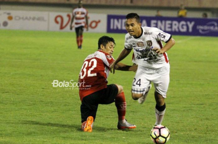 Pemain Bali United, Ricky Fajrin, beraksi melawan pemain Madura United, Beny Wahyudi, pada babak perempat final Piala Presiden 2018, di Stadion Manahan, Solo, Sabtu (3/2/2018).