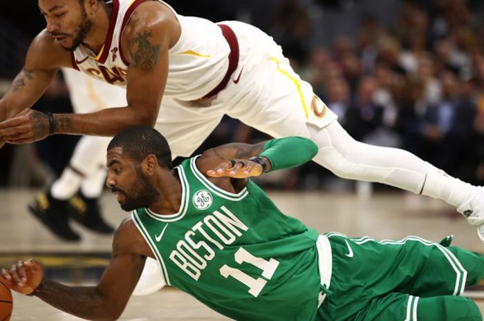 Pebasket Boston Celtics, Kyrie Irving (jersey hijau, #11), berebut bola dengan pemain Cleveland Cavaliers, Derrick Rose, pada laga pertama NBA musim 2017-2018 di Quicken Loans Arena, Cleveland, Ohio, Amerika Serikat, Rabu (18/11/2017) waktu Indonesia.