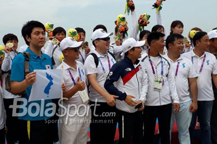 Skuat perahu naga korea bersatu merayakan keberhasilan meraih medali pertama Asian Games 2018 dari nomor 200 meter putri di Danau Jakabaring, Palembang,Sabtu (25/8/2018).