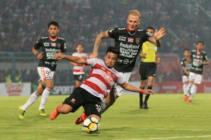 Bek Madura United, Beny Wahyudi (depan) nyaris terjatuh saat dikawal gelandang Bali United, Nick van der Velden pada laga lanjutan Liga 1 2018 di Stadion Gelora Bangkalan, 3 Juni 2018. 
