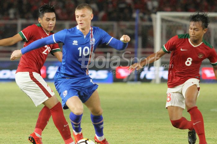 Duo pemain timnas Indonesia, M Hargianto dan Septian David Maulana (kiri) mencoba menghentikan striker timnas Islandia, Albert Gudmundsson pada uji coba internasional di Stadion Utama GBK, Jakarta Selatan, Minggu (14/1/2018) malam. 