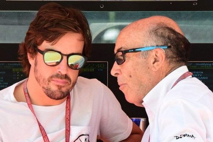 Pebalap Formula 1 asal Spanyol, Fernando Alonso (kiri), berbincang dengan CEO Dorna Sports (organisasi penyelenggara balapan MotoGP) Carmelo Ezpeleta pada sesi kualifikasi balapan MotoGP di Sirkuit Mugello, Italia, 21 Mei 2016.