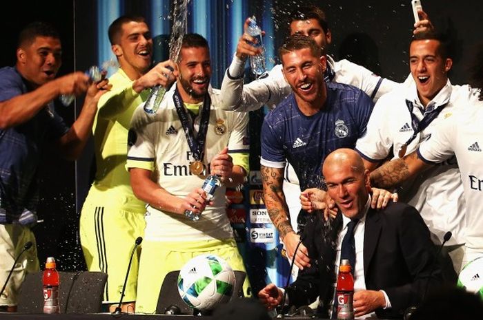 Pelatih Real Madrid, Zinedine Zidane, diguyur oleh para pemainnya saat melakoni jumpa pers pascalaga kontra Sevilla pada Piala Super Eropa 2016, Selasa (9/8/2016)