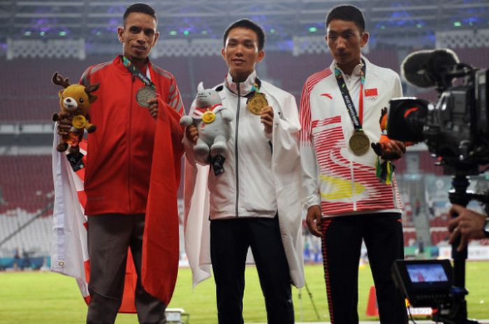 Atlet Jepang Hiroto Inoue (tengah), Elhassan Elabbassi dari Bahrain (kiri), dan Duo Bujie dari Cina memperlihatkan medalinya pada upacara penyerahan medali lari marathon putra Asian Games 2018 di Stadion Utama Gelora Bung Karno, Jakarta, Sabtu (25/8/2018). Medali emas diraih Hiroto Inoue, perak oleh Elhassan Elbbassi dan perunggu diraih Duo Bujie.