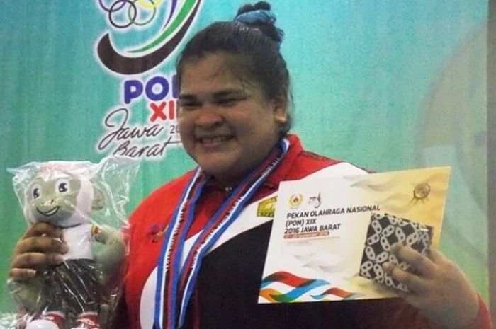 Lifter putri provinsi Aceh, Nurul Akmal, berpose dengan medali emas yang didapat dari cabang olahraga angkat besi di kelas 75 kg yang berlangsung di Gelora Sabilulungan Jalak Harupat, Kabupaten Bandung, Jumat (23/9/2016).