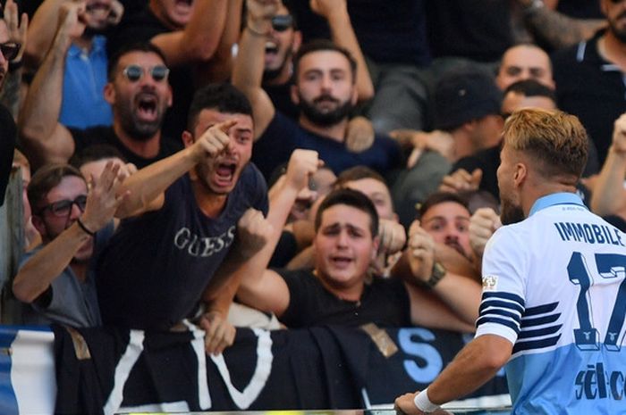 Penyerang Lazio, Ciro Immobile, merayakan golnya bersama suporter dalam laga Liga Italia kontra AS Roma di Stadion Olimpico, Roma, Italia pada 29 September 2018.