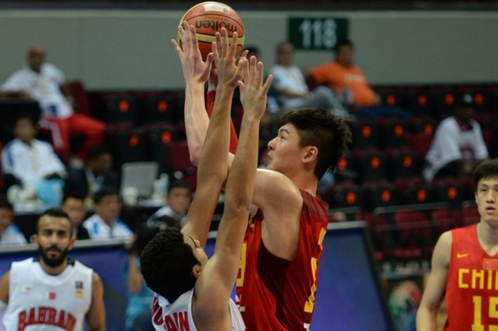 Pebasket China, Wang Zhelin (memegang bola) berupaya melepas tembakan dua angka saat membela negaranya melawan Bahrain pada Kejuaraan Asia 2013 di Manila, Filipina. China menang 88-66.