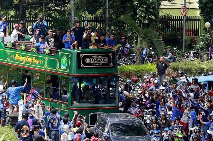 Bus dengan atap terbuka membawa para pemain dan pelatih Arema FC berkeliling di jalanan protokol Kota Malang saat konvoi trofi juara Piala Presiden 2017 pada Selasa (14/3/2017) siang. 